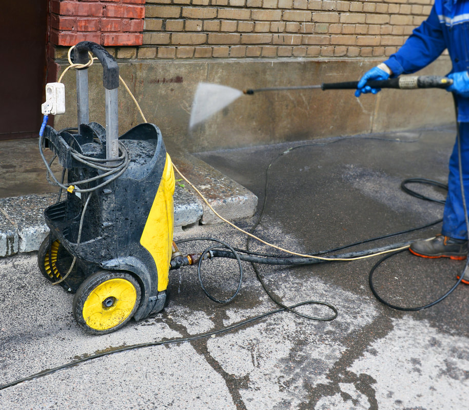 Pressure washing a concrete wall for a business