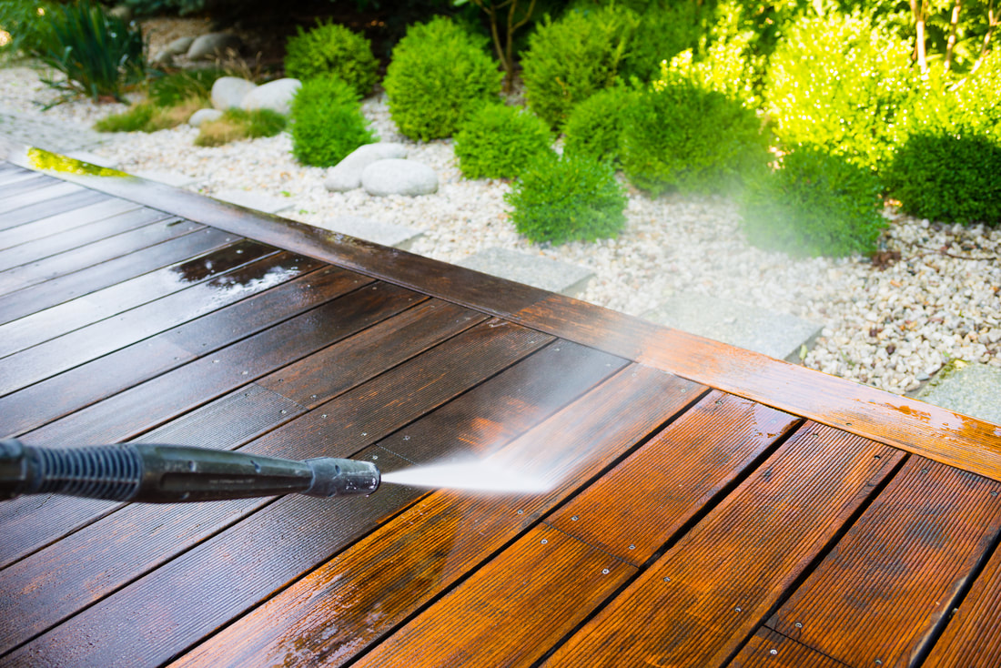 Pressure washing wood surface for stain removal.